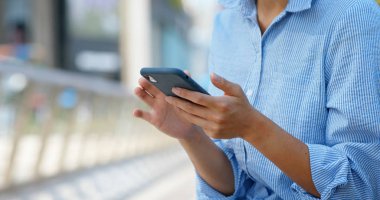 Sokakta akıllı telefon kullanan kadın