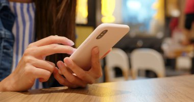 Restoranda akıllı telefon kullanan kadınlar.