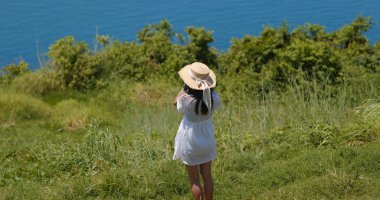 Kadın deniz kenarında fotoğraf çekiyor.