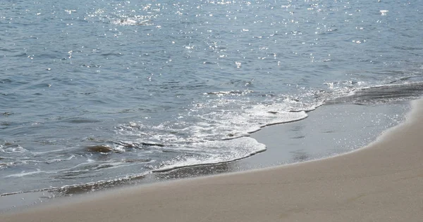 Homokos strand hullám napfény alatt — Stock Fotó