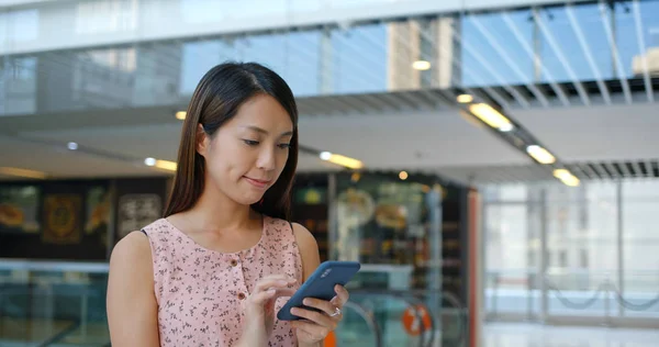 ショッピングモール内の携帯電話の女性の使用 — ストック写真