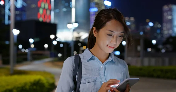 Mujer mira el teléfono móvil por la noche — Foto de Stock