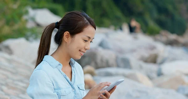 Kvinnors användning av mobiltelefon vid havet — Stockfoto