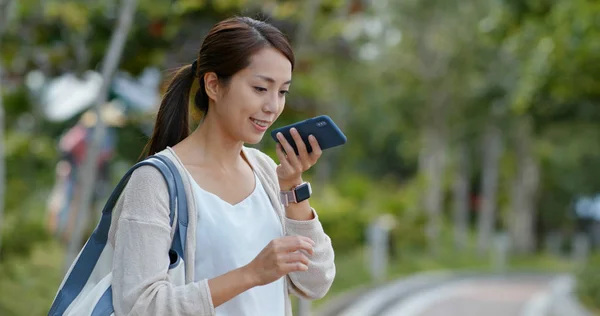 Mulher uso de telefone celular para o envio de mensagem de áudio no exterior — Fotografia de Stock