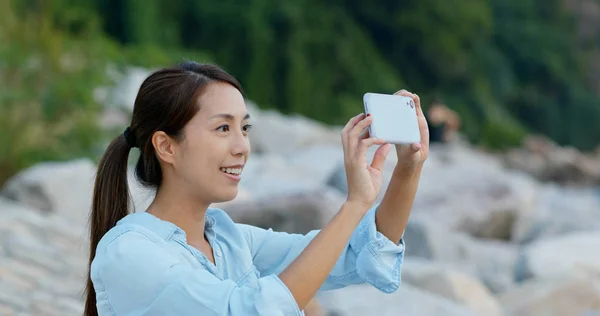 Kvinna ta foto på mobiltelefon vid havet — Stockfoto