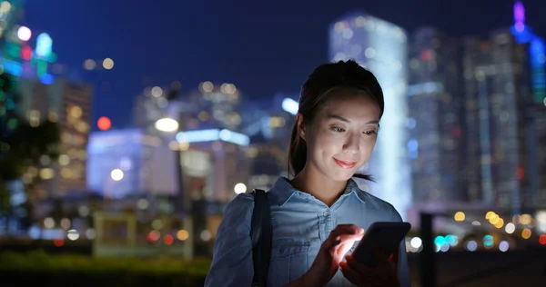 Frau nutzt Handy nachts in der Stadt — Stockfoto