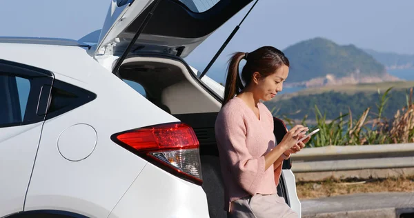 Mulher verificar no telefone inteligente na viagem de carro — Fotografia de Stock