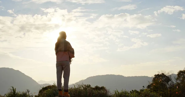 Frau schaut in den Sonnenuntergangshimmel auf dem Land — Stockfoto