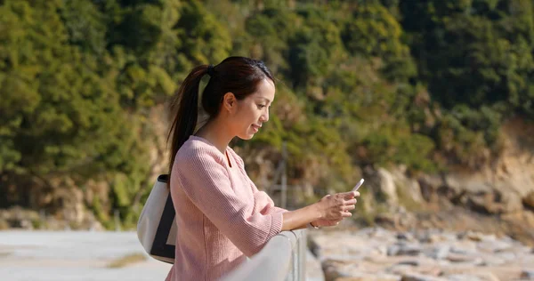 Kvinna titta på smart telefon på utomhus — Stockfoto