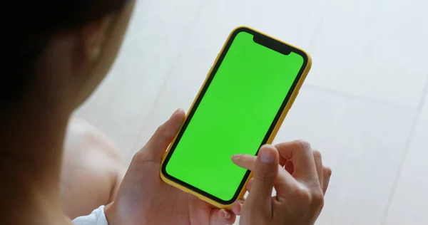 Mujer uso de teléfono móvil con pantalla verde en casa —  Fotos de Stock