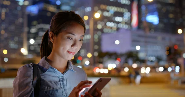 Mujer utilizar la aplicación de teléfono móvil para llamar taxi por la noche —  Fotos de Stock