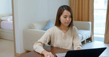 Kadın evde dizüstü bilgisayarda çalışıyor.