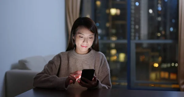 Spojrzenie kobiety na telefon komórkowy w nocy — Zdjęcie stockowe