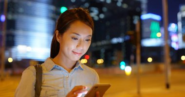 Geceleri kadın cep telefonu kullanıyor.