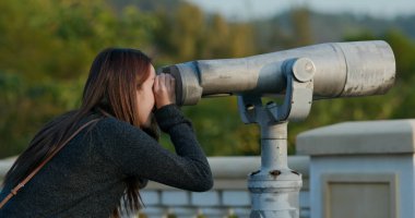 Kadın turist dürbününe bak.