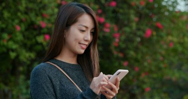 Yeşil arka planda cep telefonu kullanan kadın