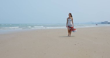 Kumsalda yürüyen bir kadın.