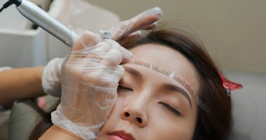 Kadın kaş mikropateni ve kalıcı makyaj yaptırıyor.