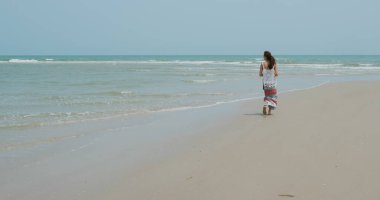 Kadınlar sahilde yürür.