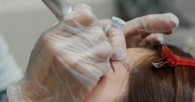 Kadın kaş mikropateni ve kalıcı makyaj yaptırıyor.