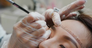 Kalıcı makyaj uzmanı kaş mikropateni dövmesi yapıyor.