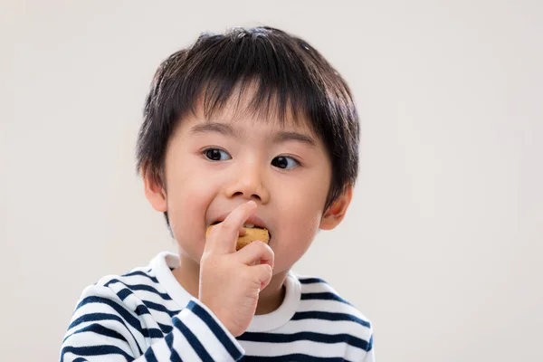 アジアの少年は白い背景でクッキーを食べる — ストック写真