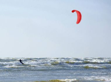 Jrmala (Letonya). Kırmızı bir paraşüt ile denizde sörf