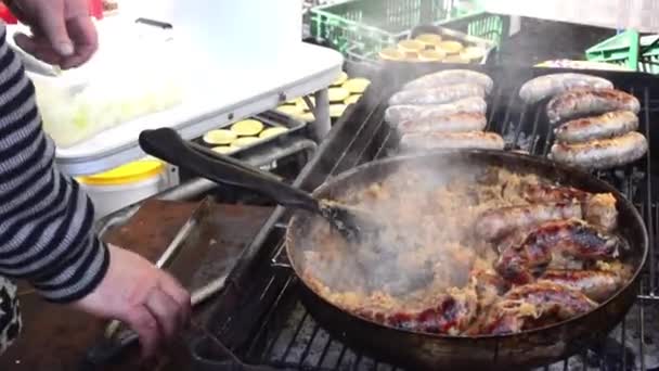 Przygotowania kiełbasy z duszona kapustą na grill. — Wideo stockowe