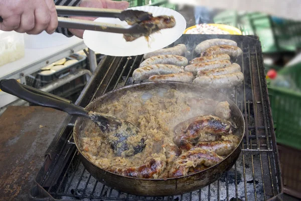 Préparation de saucisses au chou cuit sur un gril . — Photo