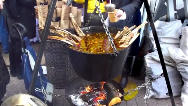 ラトビア 冬の休日の間に路上で冬に熱いスープの配布 販売準備のアクション — ストック動画