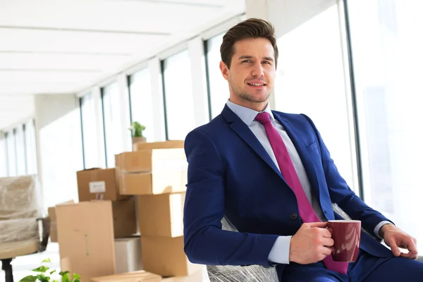 Businessman having coffee in new office — Stock Photo, Image