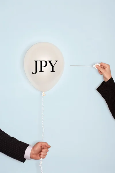 Hands holding balloon with JPY sign — Stock Photo, Image