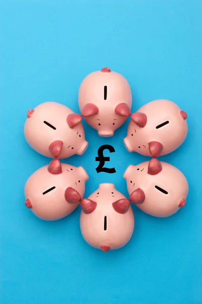Piggy banks surrounding a GBP Symbol — Stock Photo, Image