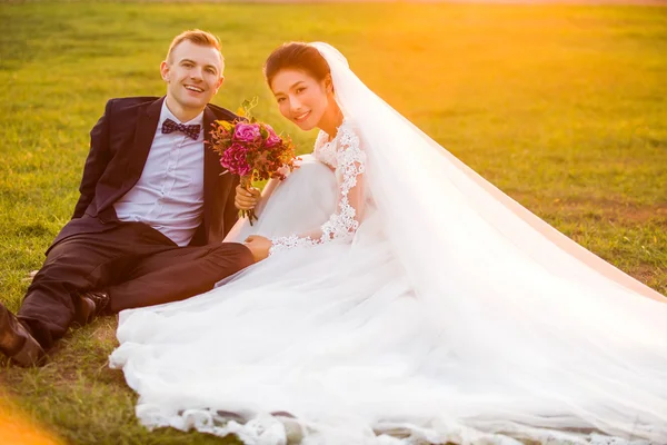 Pareja de boda sentada en el campo —  Fotos de Stock