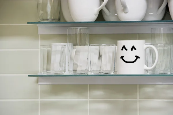 Tasse avec signe souriant sur l'étagère — Photo