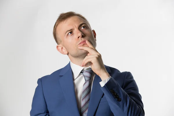 Businessman with fingers on lips thinking — Stock fotografie