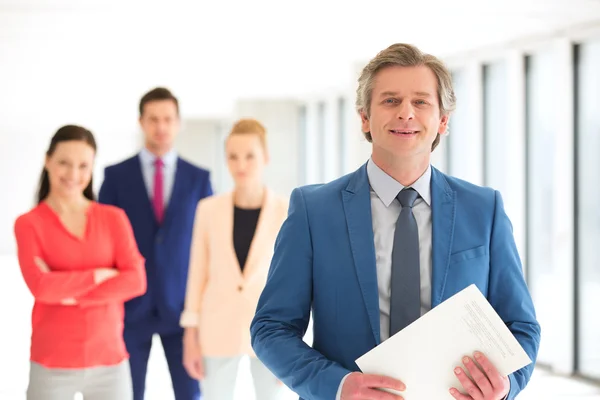 Vertrouwen zakenman met team op achtergrond op kantoor — Stockfoto