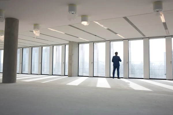 Geschäftsmann blickt durch Bürofenster — Stockfoto