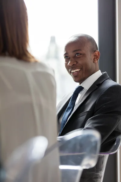 Un hombre de negocios sonriente discutiendo con una colega — Foto de Stock
