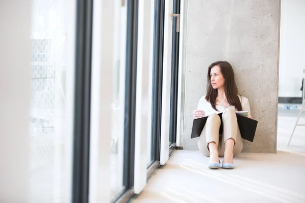 Business woman looking through office window — стоковое фото