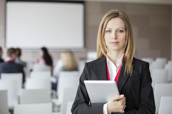 Vertrouwen zakenvrouw digitale tablet in seminar hal holding — Stockfoto