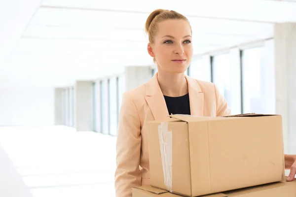 Affärskvinna som transporterar kartong lådor i office — Stockfoto