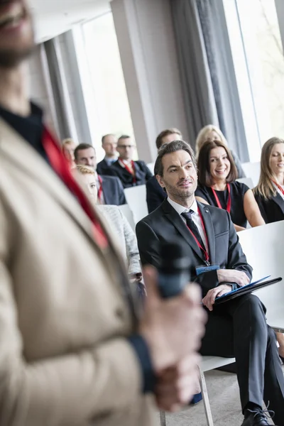 Public speaker with business people in seminar hall — Stock Photo, Image