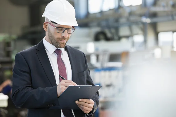 Empresario escribiendo en portapapeles — Foto de Stock