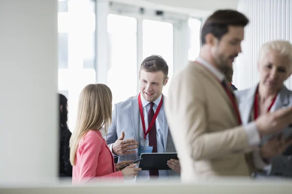 Businessman discussing with colleague in convention center — Stock Photo, Image