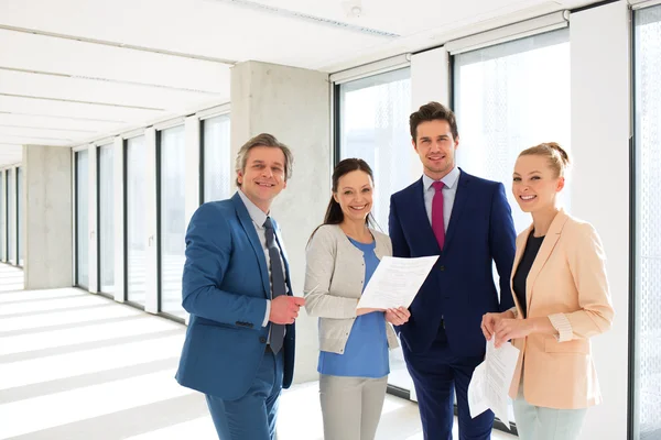 Glimlachende zakenmensen met documenten in office — Stockfoto