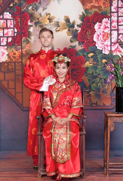 Bruid en bruidegom in Chinese bruiloft outfits — Stockfoto