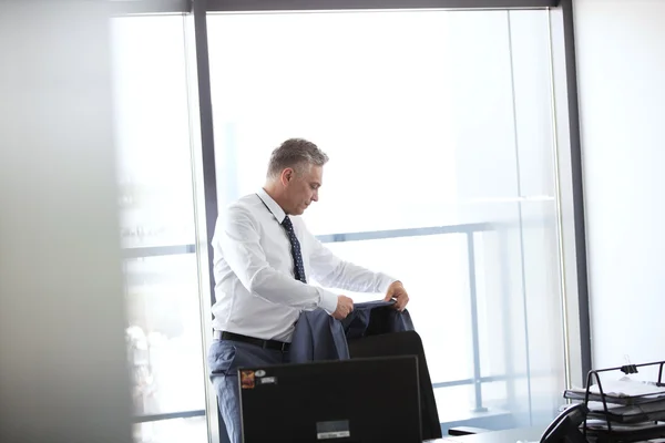 Бізнесмен вішає куртку на спині стільця — стокове фото