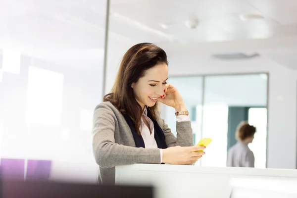 Businesswoman using mobile phone in office — Stock Photo, Image