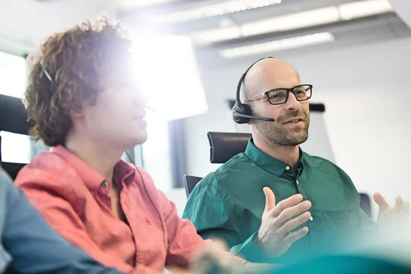 Zakenman praten op headset op kantoor — Stockfoto